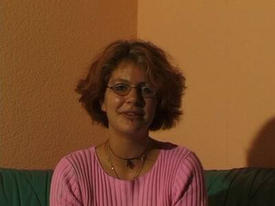 Brillenträgerin streichelt sich die rasierte Pflaume
